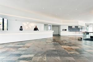 two people standing at a counter in a large room at Mainport Design Hotel in Rotterdam