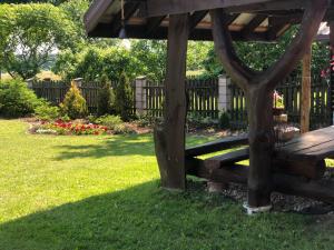 a wooden bench sitting in the grass in a yard at Apartament Hajstra z ogrodem in Grodzisk