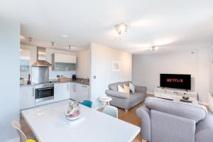 a kitchen and living room with a table and chairs at The Vizion serviced apartments from Pincott Properties - free parking, private balcony, and WiFi in Milton Keynes