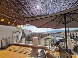 d'une terrasse avec un parasol et des chaises sur le balcon. dans l'établissement Casa de la Parra, à Bédar