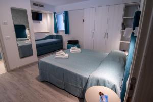 sypialnia z niebieskim łóżkiem i niebieską kanapą w obiekcie HOTEL ADRIA BEACH w Rimini