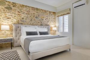 una camera con un grande letto e un muro di pietra di THIRAMENOUS RESIDENCE ad Atene