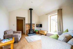 een woonkamer met een bank en een open haard bij Brecks Farm - The Tractor Shed in York