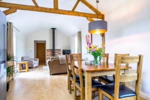 comedor y sala de estar con mesa y sillas en Brecks Farm - The Tractor Shed en York