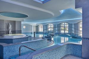 a large swimming pool in a hotel room at Travel Charme Kurhaus Binz in Binz