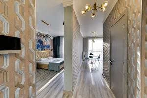 a hotel room with a hallway with a bed and a door at Новая квартира люкс в центре ЖК "Атлант" in Astana