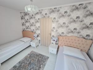 エゲルサロークにあるBorostyán Vendégházの花柄の壁紙を用いたベッドルーム1室(ベッド2台付)