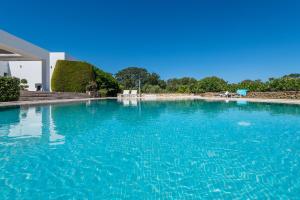 a large swimming pool with blue water at Villa Syndriani in Paradeísi