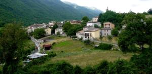 un petit village sur une colline avec des arbres et des maisons dans l'établissement casa indipendente con camino tra leonessa e amatrice, à Favischio