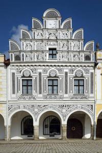 Un edificio alto y blanco con muchas ventanas. en Renaissance Vintage Apartment A1, en Telč