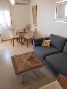 sala de estar con sofá azul y mesa en Casa Santiago de la Ribera en Santiago de la Ribera