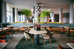 un comedor con mesas y sillas con plantas en Van der Valk Hotel Deventer, en Deventer