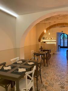 uma sala de jantar com mesas e cadeiras e um arco em Albergo Roma em Buonconvento