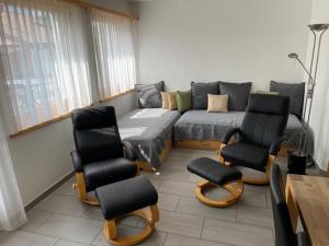 ein Wohnzimmer mit einem Sofa und Stühlen in der Unterkunft Chasa Mundin in Scuol