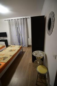 um quarto com uma cama, uma mesa e uma janela em Agropensiune CASA SONIA em Băcia