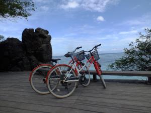 dwa rowery zaparkowane obok siebie na promenadzie w obiekcie Wisma Bunda w Gili Trawangan