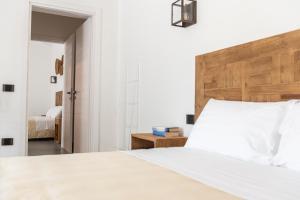 a bedroom with a white bed with a wooden headboard at Albergo Rurale Casa Fois in Valledoria