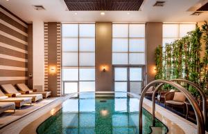 a pool in the lobby of a hotel at Kfar Maccabiah Business & Sport Hotel in Ramat Gan