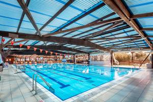a large swimming pool with a blue ceiling at Kfar Maccabiah Business & Sport Hotel in Ramat Gan