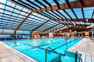 a large swimming pool with people in it at Kfar Maccabiah Business & Sport Hotel in Ramat Gan