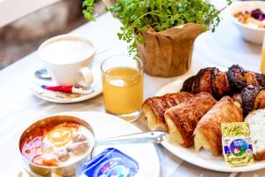 a table with a plate of breakfast foods and a cup of coffee at Kfar Maccabiah Business & Sport Hotel in Ramat Gan
