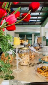 a buffet with red flowers on a table with food at Hotel Vallisdea in Sala Consilina