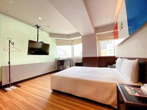 um quarto de hotel com uma cama e uma televisão de ecrã plano em Hotel 6 - Ximen em Taipei