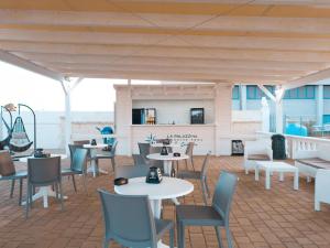 a patio with tables and chairs on a roof at La Palazzina Bed & Breakfast in Porto Cesareo