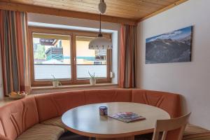 a living room with a couch and a table at Die Pension - Margreiter in Saalbach-Hinterglemm