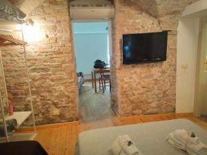a room with a tv on a stone wall at La finestra sul cortile in Atri