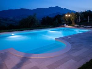 a swimming pool at night with mountains in the background at agriturismo borgo del ginepro in Castiglione Messer Raimondo