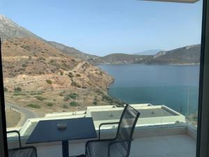 a balcony with a table and chairs and a view of a lake at Caldera Blue in Alikí
