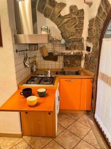 a kitchen with an orange counter top and a stove at Tempesta Home in Lanusei +20 photos