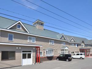 a large building with cars parked in front of it at Pension Arumeria in Wakkanai