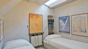 a bedroom with two beds and a painting on the wall at Cala D'Oria in Lerici