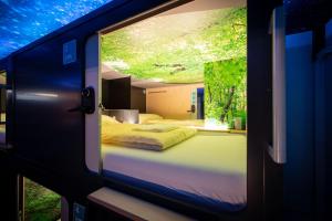 uma vista para um quarto com uma cama através de uma janela em Capsule Hotel - theLAB em Lucerna