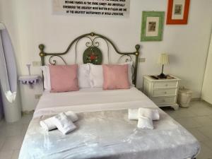 a bedroom with a large bed with pink and white pillows at 6 Keys in Pisa