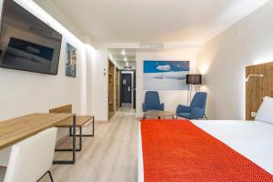 Habitación de hotel con cama, escritorio y sillas en Exe Prisma en Andorra la Vella