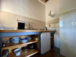 a kitchen with a sink and a counter with dishes at Window to Bagno Vignoni in Bagno Vignoni