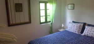 Un dormitorio con una cama azul y una ventana en cottage, en Abragão