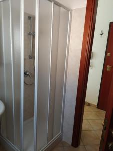 a shower with a glass door in a bathroom at LA CALA in Olbia