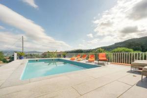 una piscina con tumbonas naranjas en cottage, en Abragão