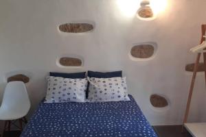 una camera da letto con un letto con cuscini blu e bianchi di cottage ad Abragão