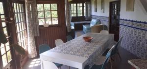 una sala da pranzo con tavolo, sedie e finestre di cottage ad Abragão