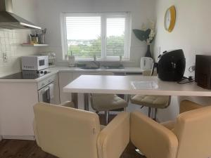 een keuken met een tafel, stoelen en een aanrecht bij Hillcrest House Self Catering Apartments in Donegal