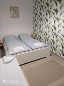 a bedroom with a bed and a wall at Erdei Apartman Hajdúszoboszló in Hajdúszoboszló