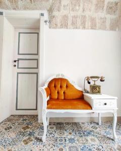 a white bench with an orange seat in a room at RomAntica in Polignano a Mare