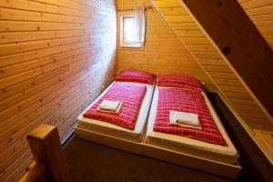 a bedroom with two beds in a wooden room at Penzion Damisport in Donovaly