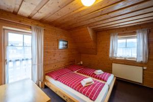 a bedroom with a red bed in a wooden room at Penzion Damisport in Donovaly +14 photos