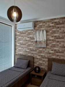 um quarto com 2 camas e uma parede de tijolos em Lighthouse 3 bedrooms villa F36 em Balchik